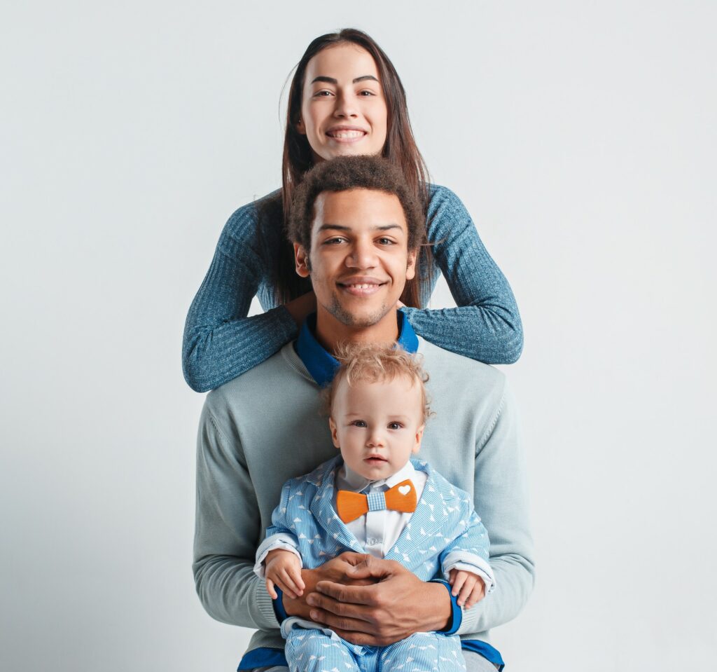 Des parents avec leur enfant prennent la pose dans un studio photo.