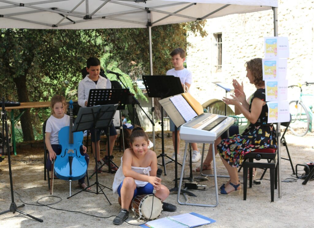 Qutra jeunes musiciens membre du petit orchestre se produisent en public avec leur professeure