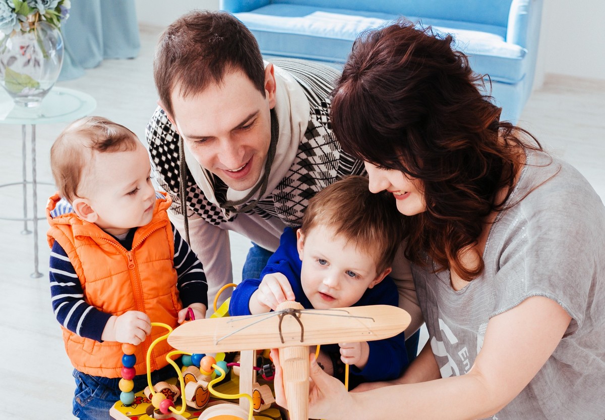 The mother,father and sons playing with toys