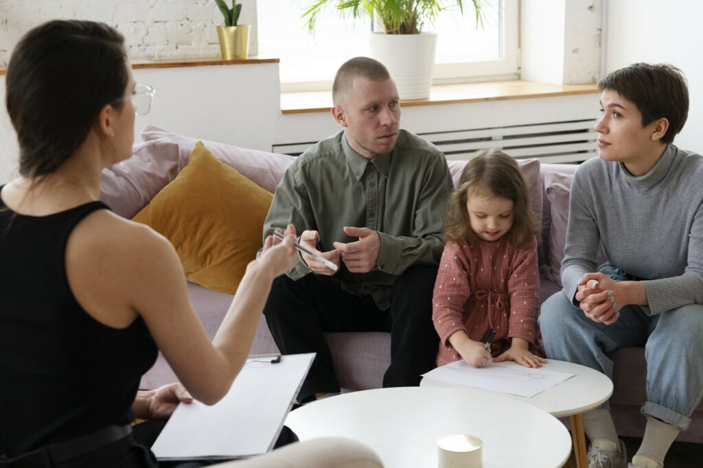 Deux parents et leur petite fille discutent avec une psychologue.